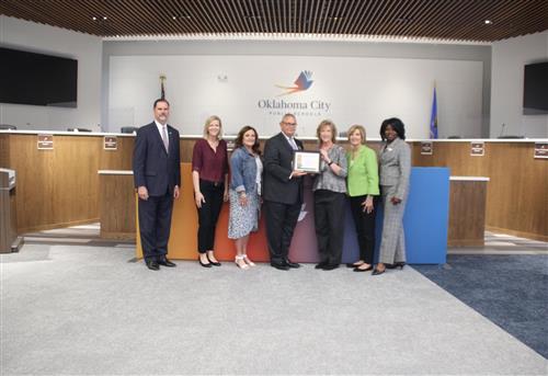 Principal Kandy Bishop receives the certificate designating OKCPS Monroe Elementary School as a Great Expectations Model Scho